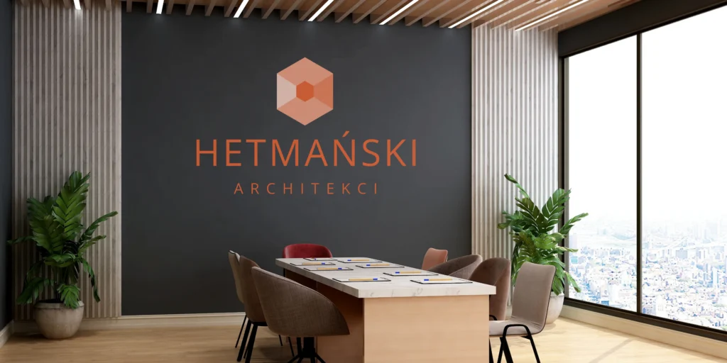 Logo firmy architektonicznej wykonane metodą druku ściennego na ciemnej ścianie w nowoczesnej sali konferencyjnej.